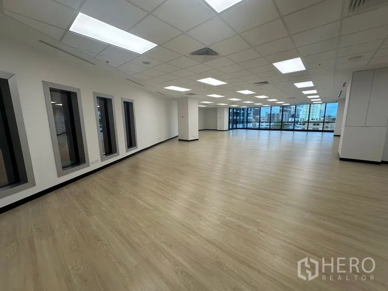 Office Space for rent in Chatuchak, Bangkok - Open-plan workspace with internal windows, columns and full-height glazing along one side.