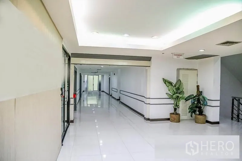 Office Space for rent in Bang Na, Bangkok - Clean lobby corridor with bright lighting, potted plants, and a glass entry.