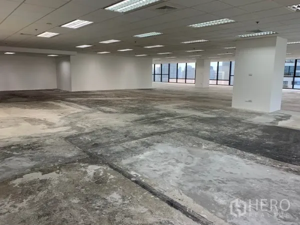 Office Space for rent in Ratchathewi, Bangkok - Unfurnished office interior with drop ceiling lights, columns, and concrete subfloor.
