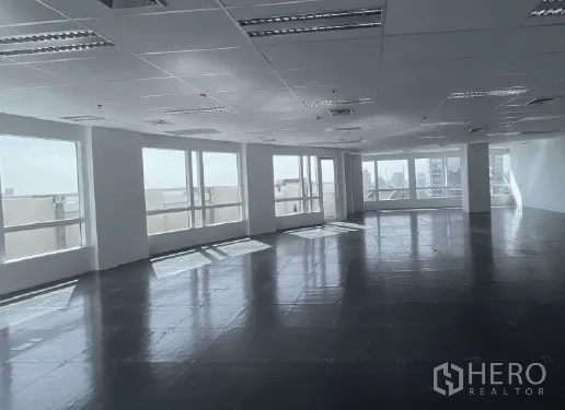 Office Space for rent - Sunlit open office with wide windows and a glass door along the window line, ready for custom fit-out.