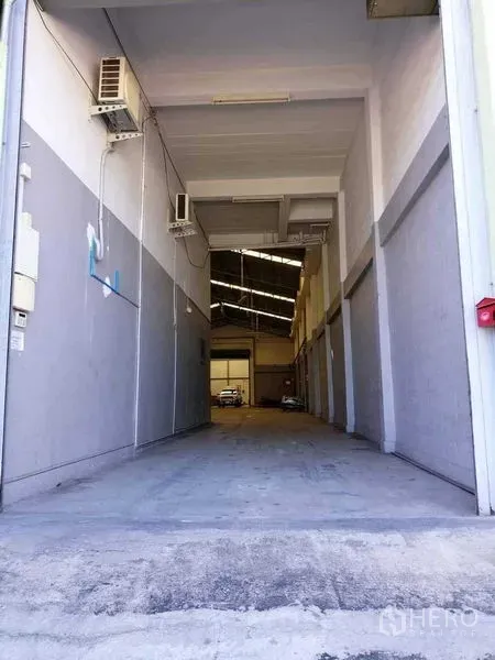 Warehouse for rent in Samut Prakan - Drive-in covered loading entrance with high clearance and industrial lighting.