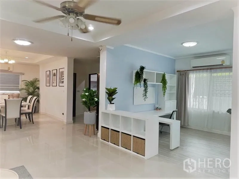 Detached House for rent in Suan Luang, Bangkok - Open-plan living, dining and workspace with glossy floors, ceiling fan and built-in storage.