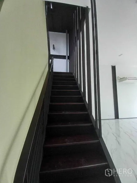Retail Space for rent in Khlong Toei, Bangkok - Black metal staircase leading to the upper level in an open-plan retail space.