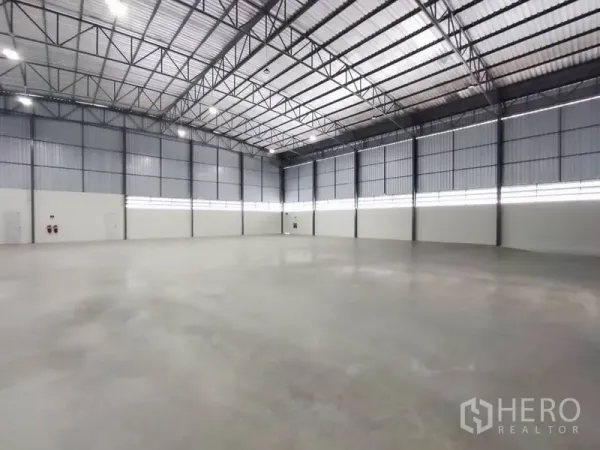 货栈 出租在Bang Phli, Samut Prakan - 仓库内部高挑钢结构屋顶与抛光混凝土地面，空间开阔。