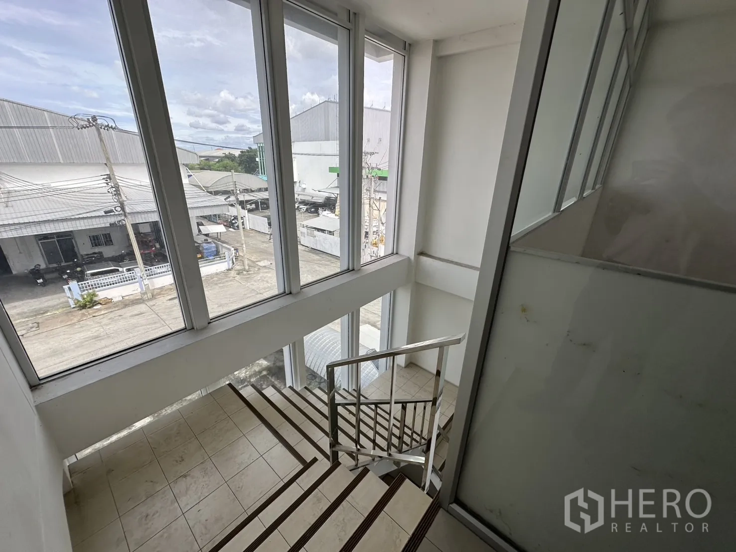 Factory for rent - Stairwell with tall windows providing natural light to the office block.