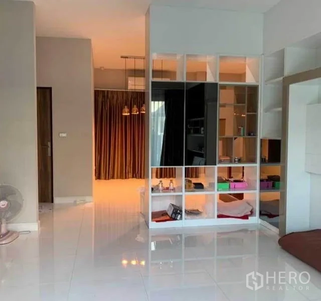 Detached House for sale in Mueang Pathum Thani, Pathum Thani - Open-plan room with a white shelving divider and polished tile flooring creating extra storage.