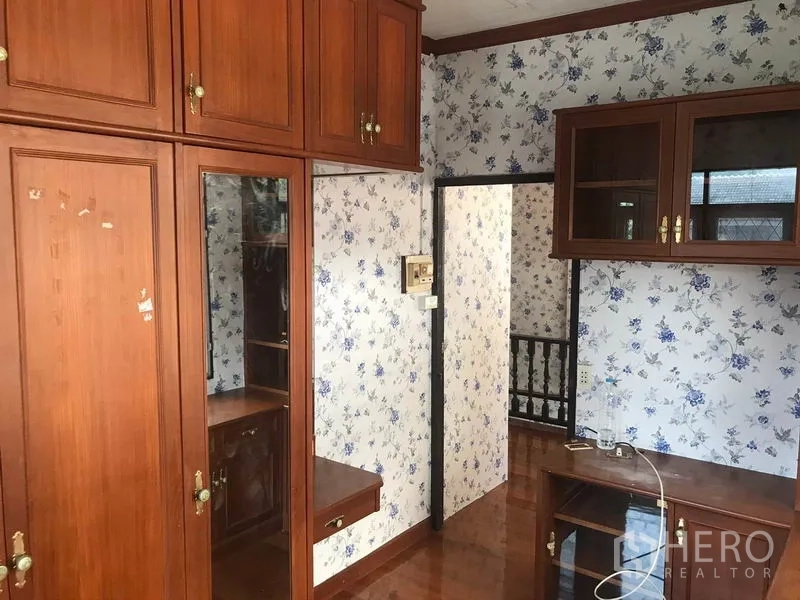 Detached House for rent in Sathon, Bangkok - Second bedroom with extensive built-in cabinets and floral walls.
