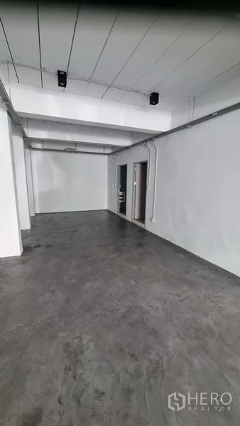 Shophouse for rent in Khlong Toei, Bangkok - Rear section of the shop floor showing access to a restroom and service area.