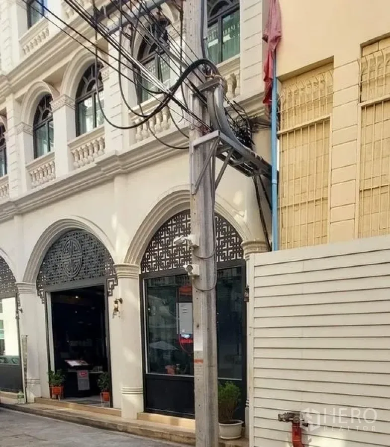 Retail Space for rent in Watthana, Bangkok - Arched white facade with glass storefront and decorative lattice panels.