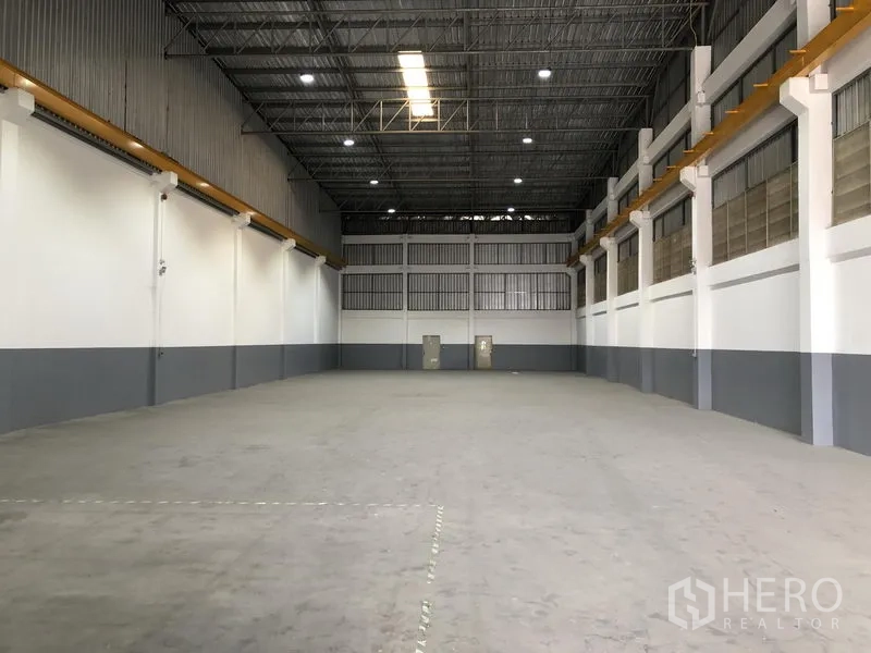 Factory for rent or sale in Bang Phli, Samut Prakan - Wide, column-free warehouse floor with bright LED lighting and ventilated upper windows.
