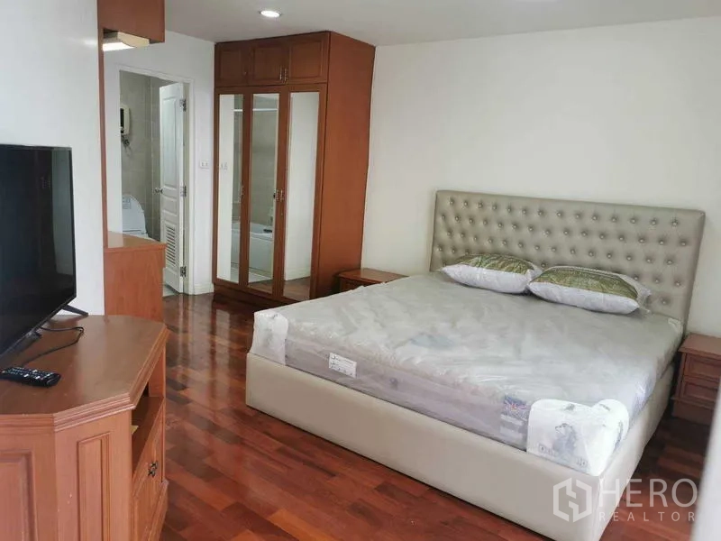 Condominium for rent - Master bedroom with upholstered bed, mirrored wardrobe and ensuite bathroom.