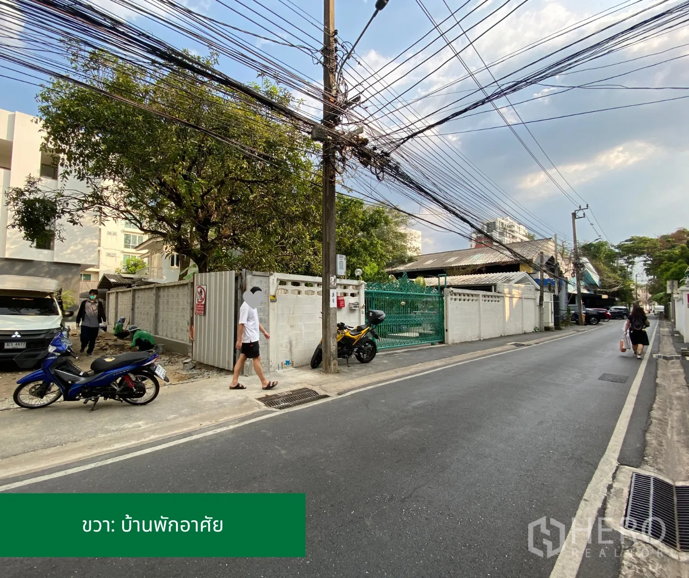Land for rent in Phaya Thai, Bangkok - Street scene to the right of the entrance with houses and overhead utilities.