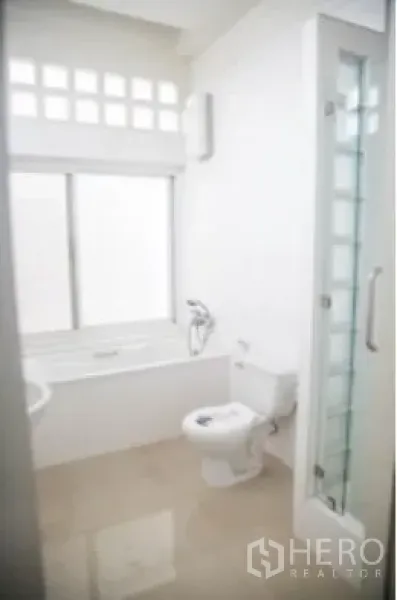独立式住宅 出租在Khlong Toei, Bangkok - 白色卫浴，带浴缸、独立玻璃淋浴间和马桶。