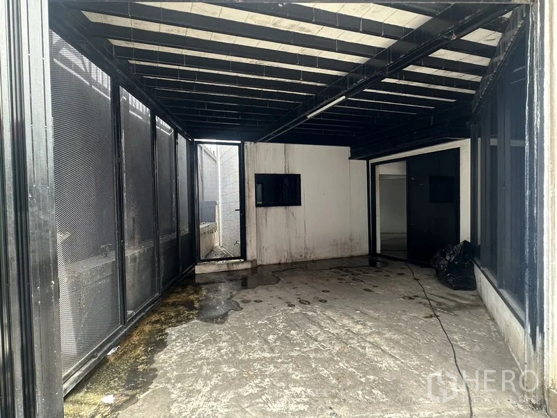 Home Office for rent or sale in Bang Na, Bangkok - Covered utility area with mesh panels and concrete floor.