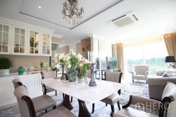 Detached House for rent or sale in Lat Phrao, Bangkok - Elegant dining space with marble table, built-in glass cabinets and wide windows.