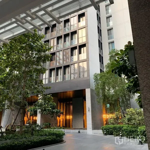 Condominium for rent in Pathum Wan, Bangkok - Modern condominium entrance with landscaped courtyard and tall facade in Pathum Wan.