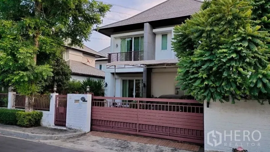Detached House for rent in Prawet, Bangkok - Modern two-storey detached house front with sliding gate, carport and mature trees.