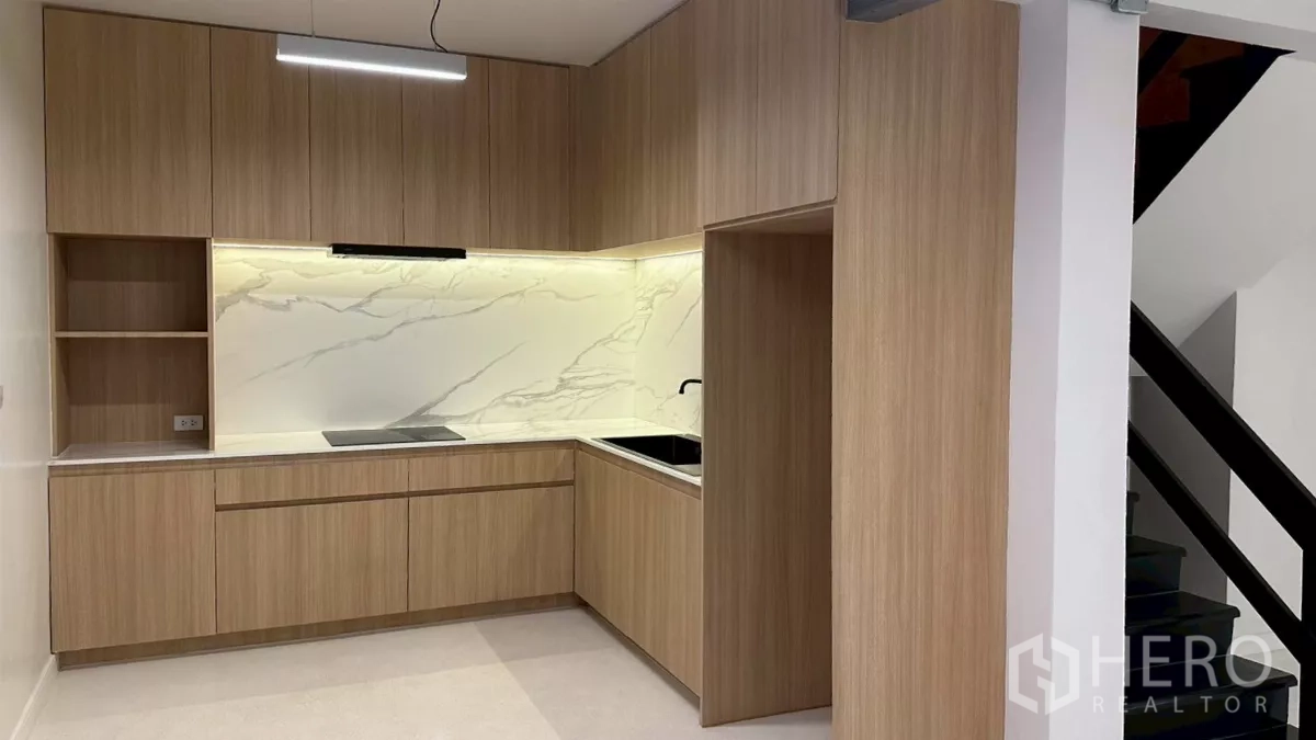 带办公室的家 出租在Watthana, Bangkok - 内置L形茶水间，木纹柜体与大理石纹挡板。