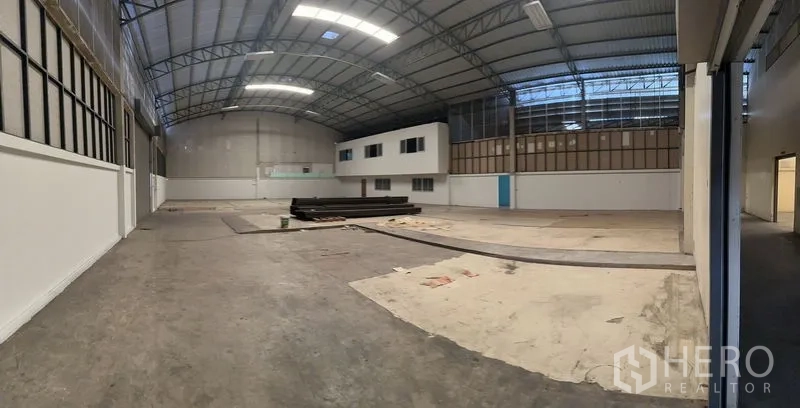 Warehouse for rent in Bueng Kum, Bangkok - Spacious warehouse interior with high arched steel roof, skylights, smooth concrete floor and a two-storey internal office block.