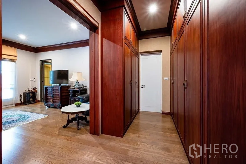 Detached House for sale in Prawet, Bangkok - Walk-in wardrobe corridor with built-in wooden cabinets.