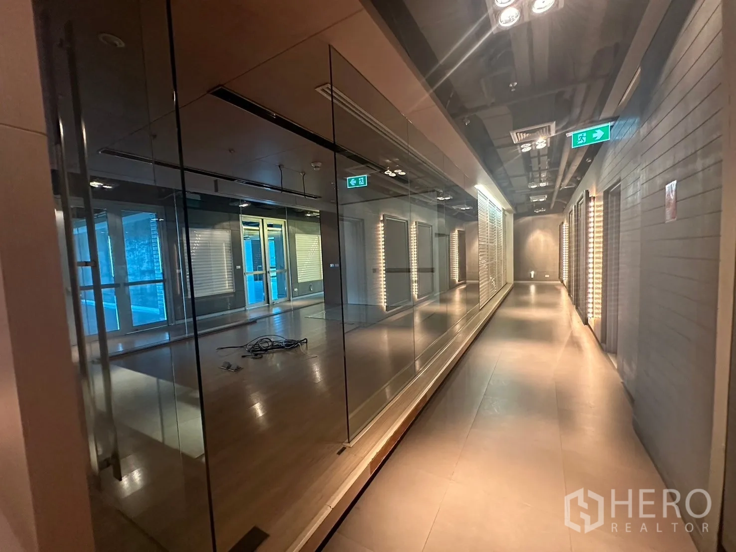 Office Space for rent in Khlong Toei, Bangkok - Contemporary corridor with full-height mirrors and track lighting.