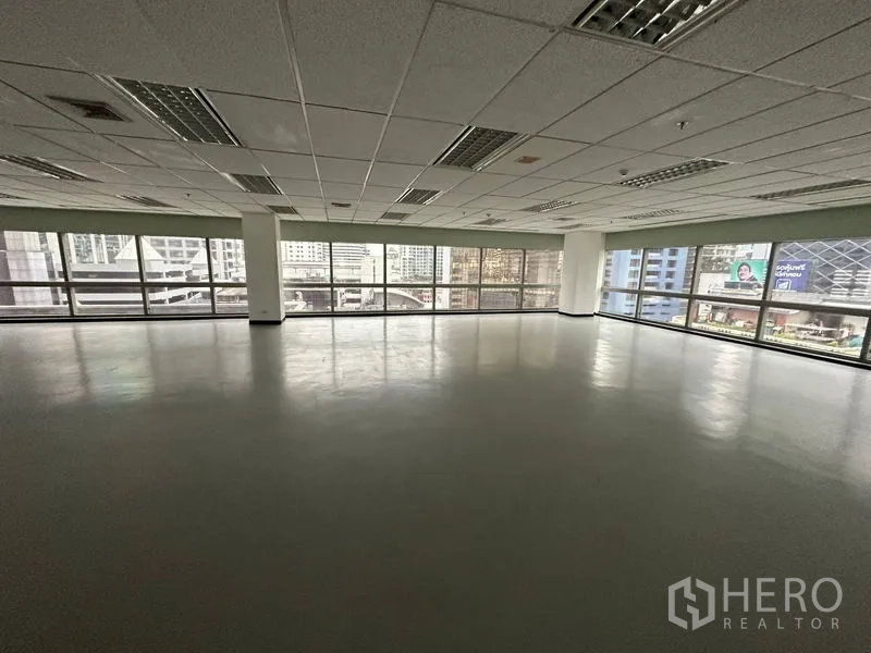 Office Space for rent - Bright office floor with wide glass windows facing Bangkok city buildings.