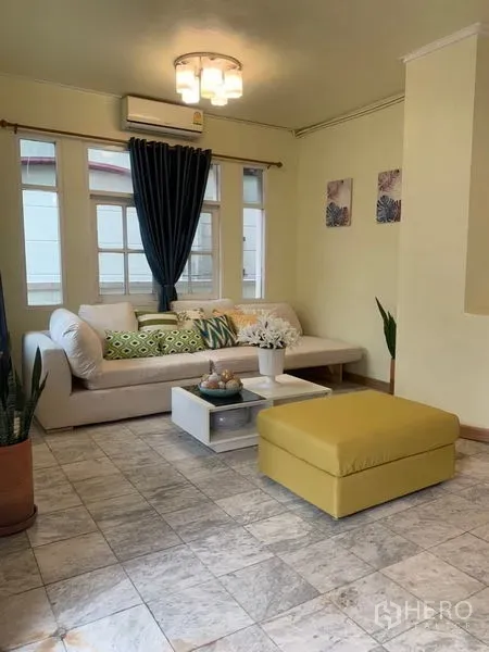 带办公室的家 出租在Suan Luang, Bangkok - 客厅配转角沙发、脚凳、窗帘与瓷砖地面