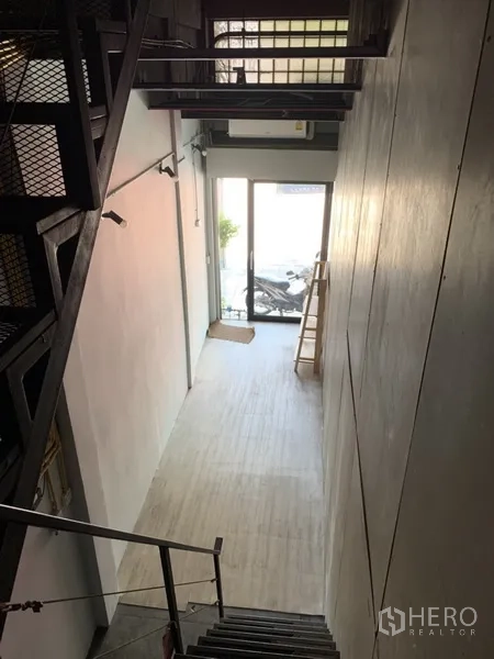店屋 出租在Watthana, Bangkok - 一层挑高入口，推拉玻璃门与金属楼梯。