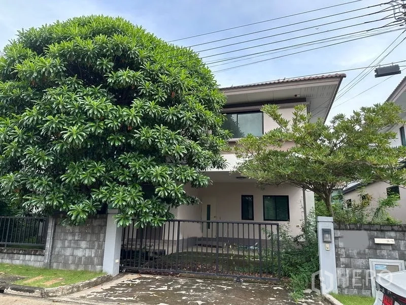 独立式住宅 出售在Bang Khen, Bangkok - 两层独栋别墅，带大门车棚与门前茂盛大树。