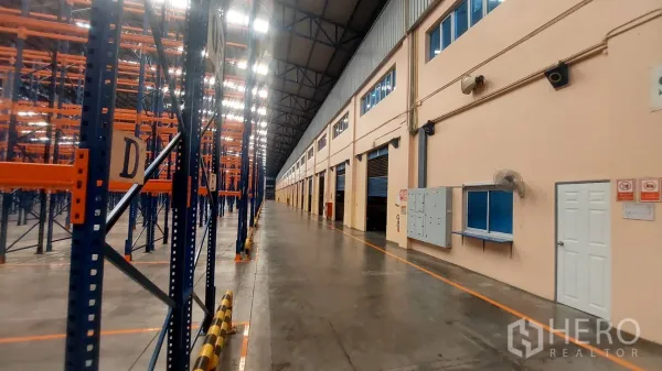 Warehouse for rent in Mueang Pathum Thani, Pathum Thani - Long aisle in a high-bay warehouse with pallet racking and multiple loading bays.
