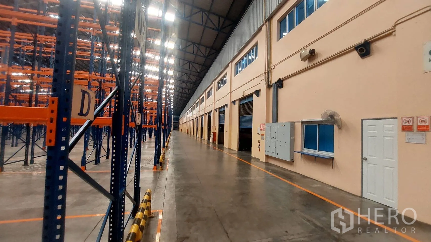 Warehouse for rent in Mueang Pathum Thani, Pathum Thani - Long aisle in a high-bay warehouse with pallet racking and multiple loading bays.