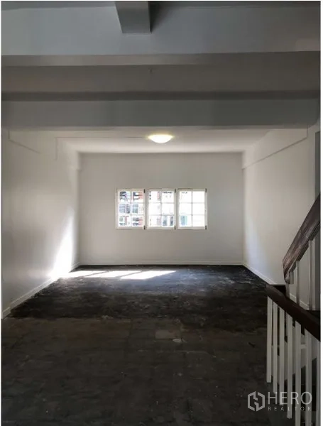 Shophouse for rent in Watthana, Bangkok - Long open room with window and ceiling light, ideal for office or retail.