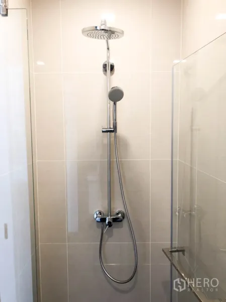 Condominium for rent in Khlong Toei, Bangkok - Glass-enclosed bathroom featuring a chrome rain shower and handheld shower.