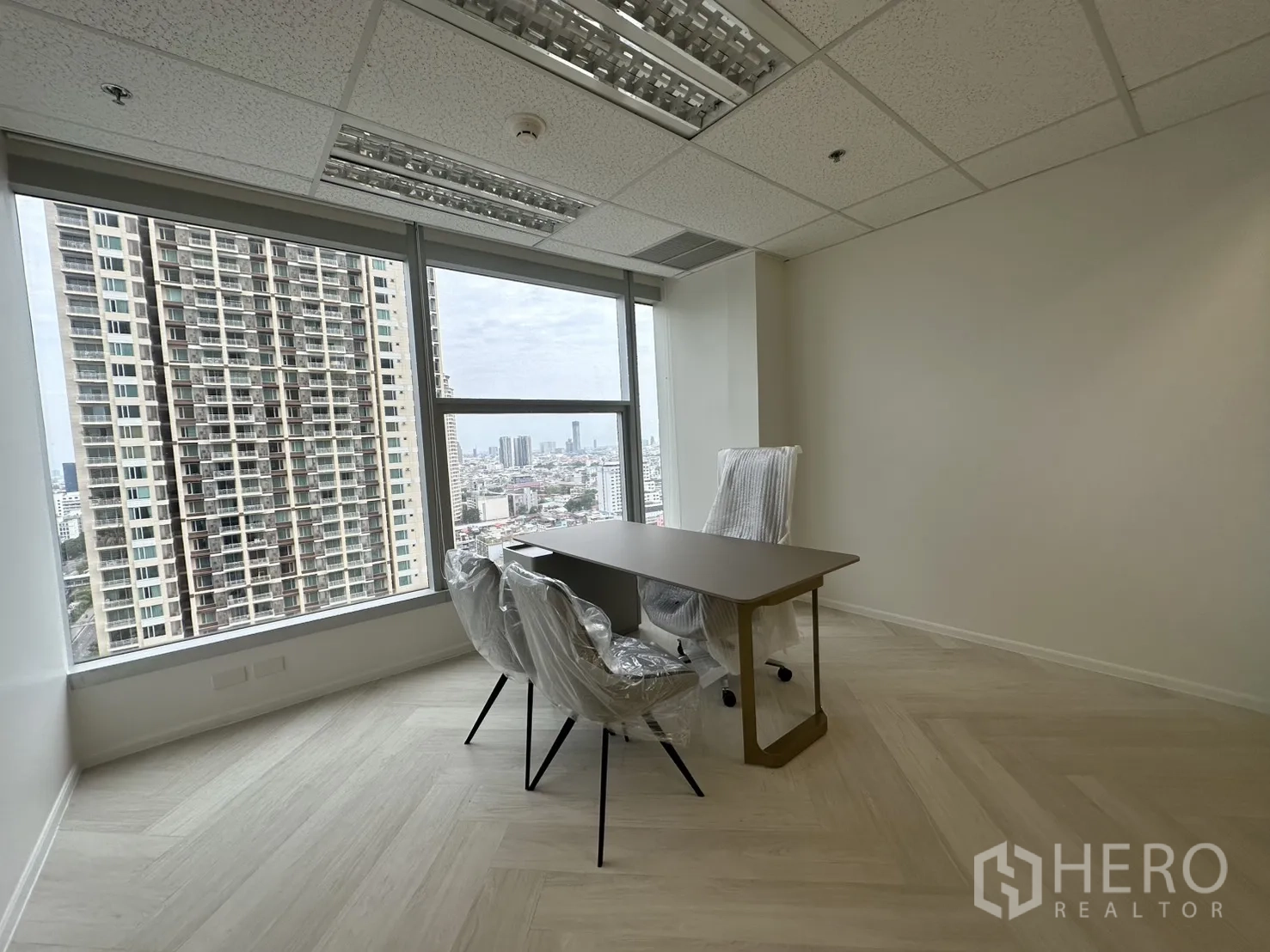 Office Space for rent in Sathon, Bangkok - Private executive office with a desk and two chairs facing floor-to-ceiling windows.