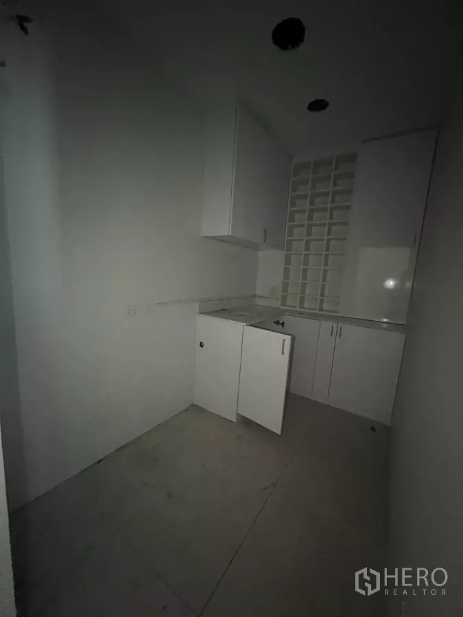 Retail Space for rent - Dim kitchenette view with white cabinetry and counter.