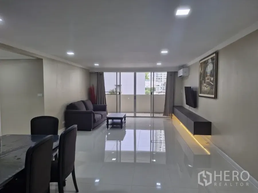 Condominium for rent in Watthana, Bangkok - Bright open-plan living room with sofa, TV wall and balcony at D. S. Tower 2.