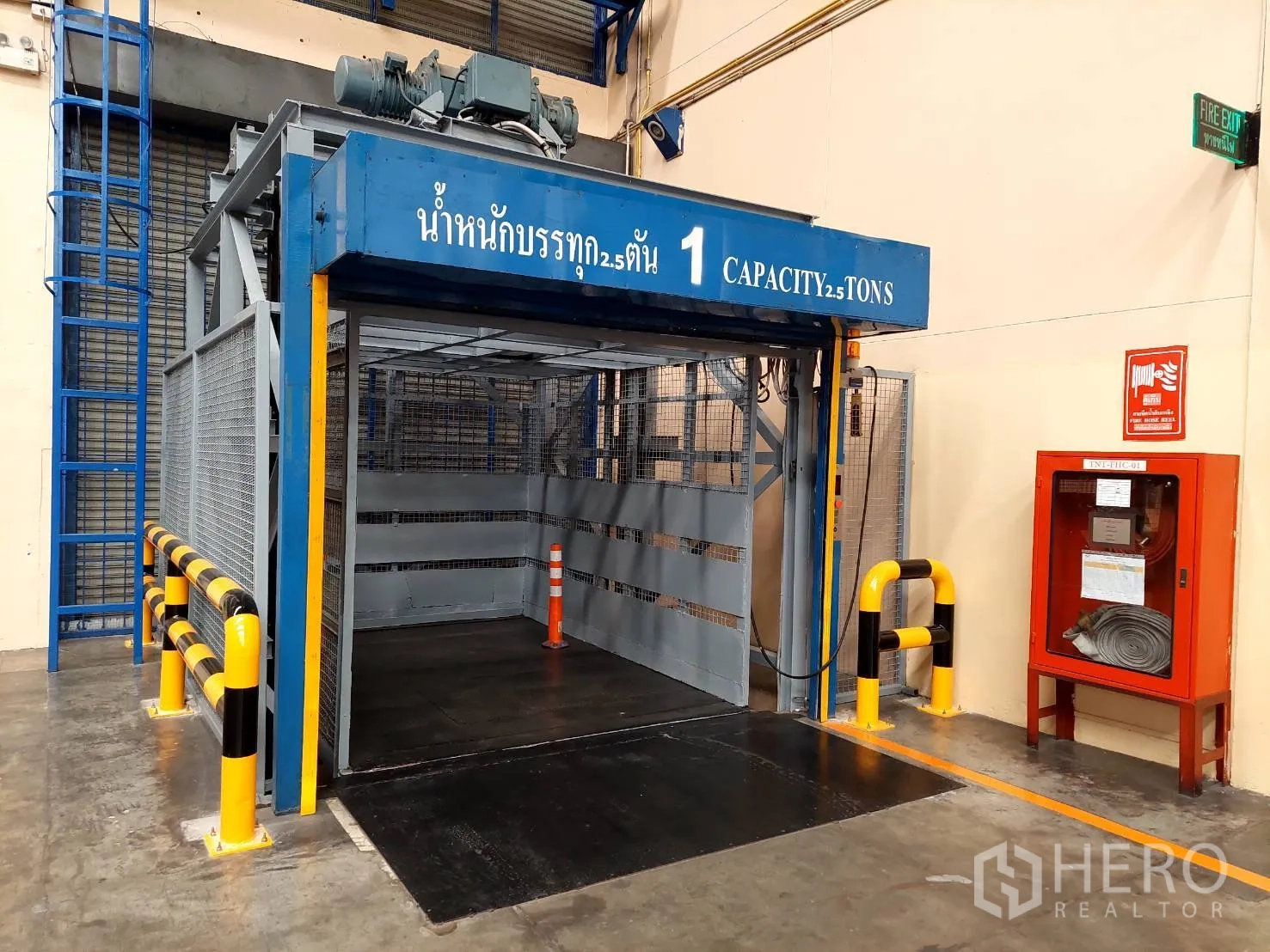 Warehouse for rent in Mueang Pathum Thani, Pathum Thani - 2.5-ton freight lift with safety bollards next to a fire hose cabinet.