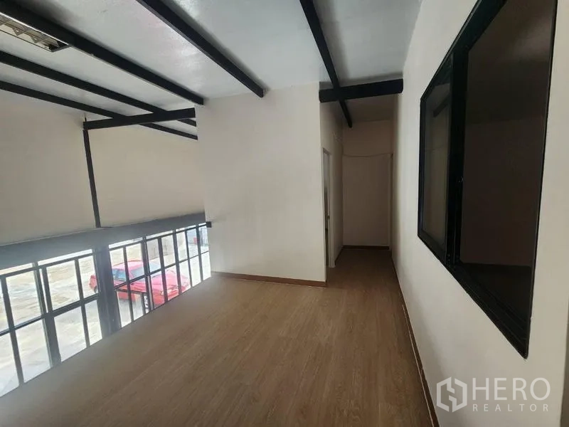 Warehouse for rent in Suan Luang, Bangkok - Mezzanine corridor with wood-look flooring and exposed black steel beams.