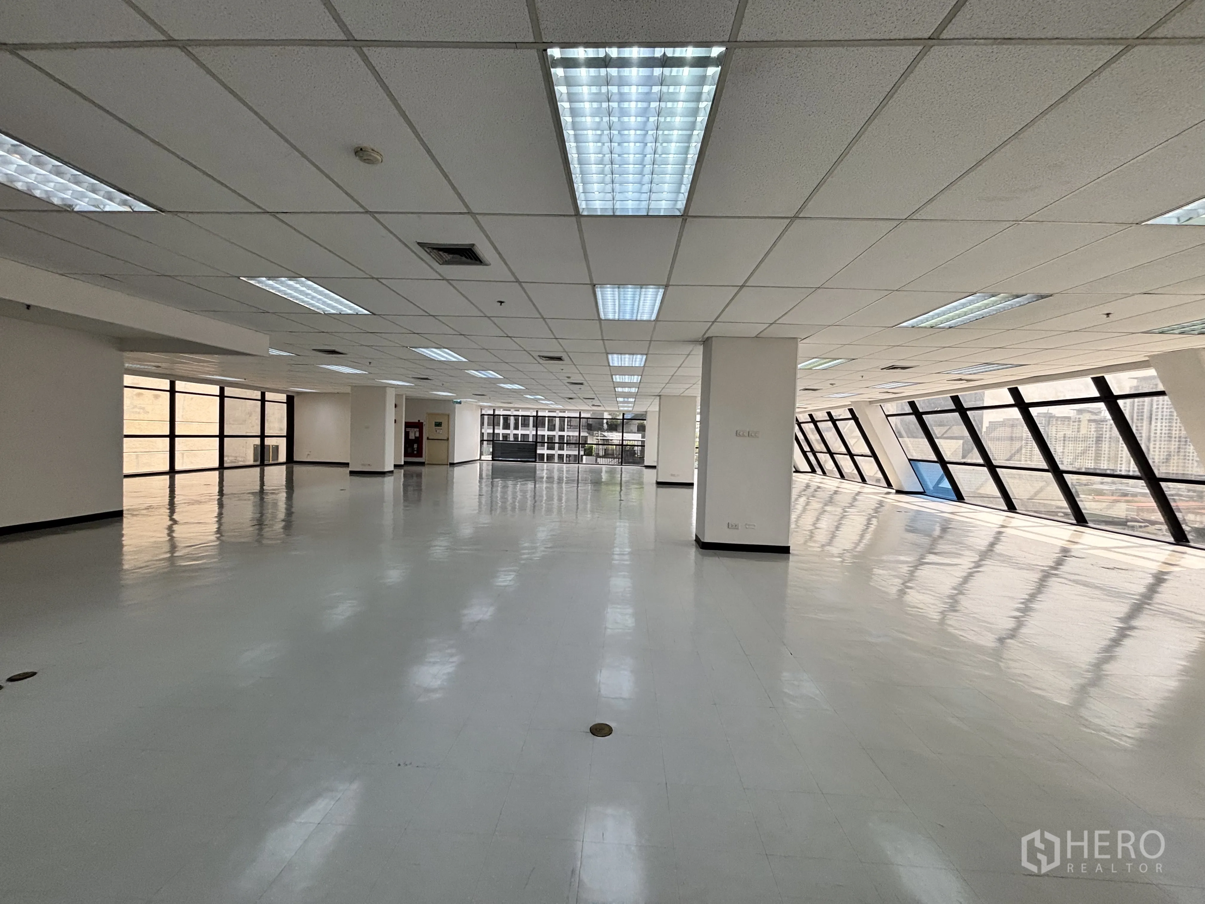 Office Space for rent in Ratchathewi, Bangkok - Expansive office level with a long stretch of angled windows and several floor power ports visible.