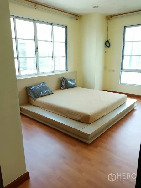 公寓 出租在Khlong Toei, Bangkok - 卧室采光充足，平台床与转角窗，可远眺城市天际线