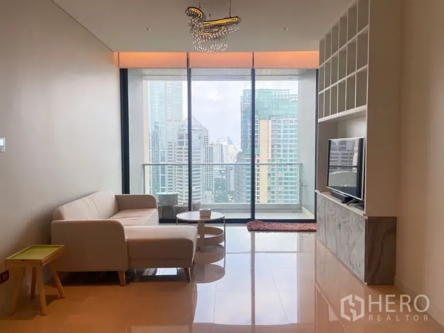Condominium for rent in Pathum Wan, Bangkok - Living area facing full-height glass and balcony with expansive city views.