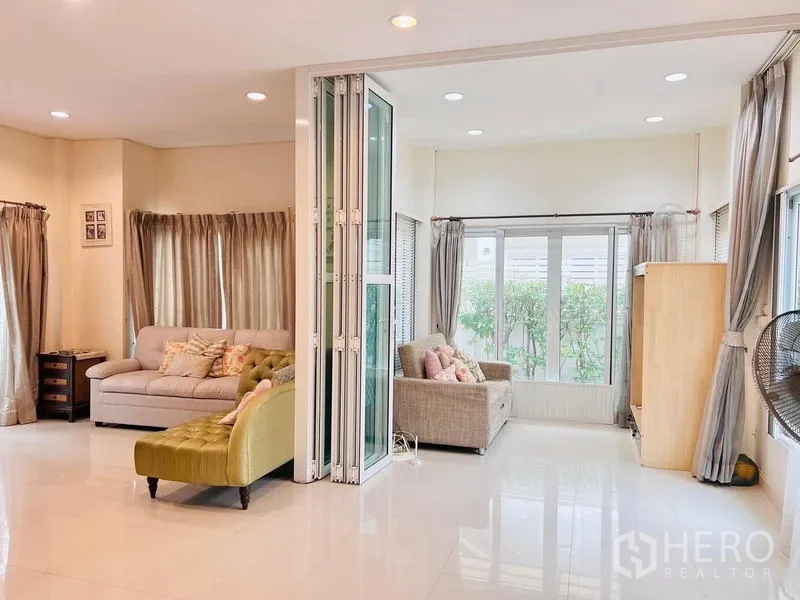 Detached House for rent - Spacious living zone with folding glass partition opening to a sunroom and garden views.