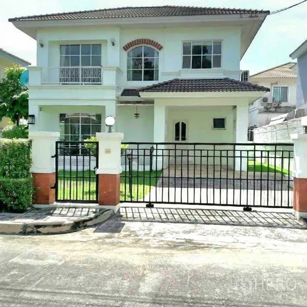 Detached House for rent in Prawet, Bangkok - Front elevation of the two-storey house with black sliding gate and covered driveway.