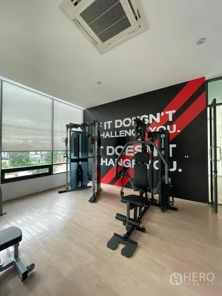 Townhouse for rent in Prawet, Bangkok - Gym room with weight machines and a motivational wall graphic.