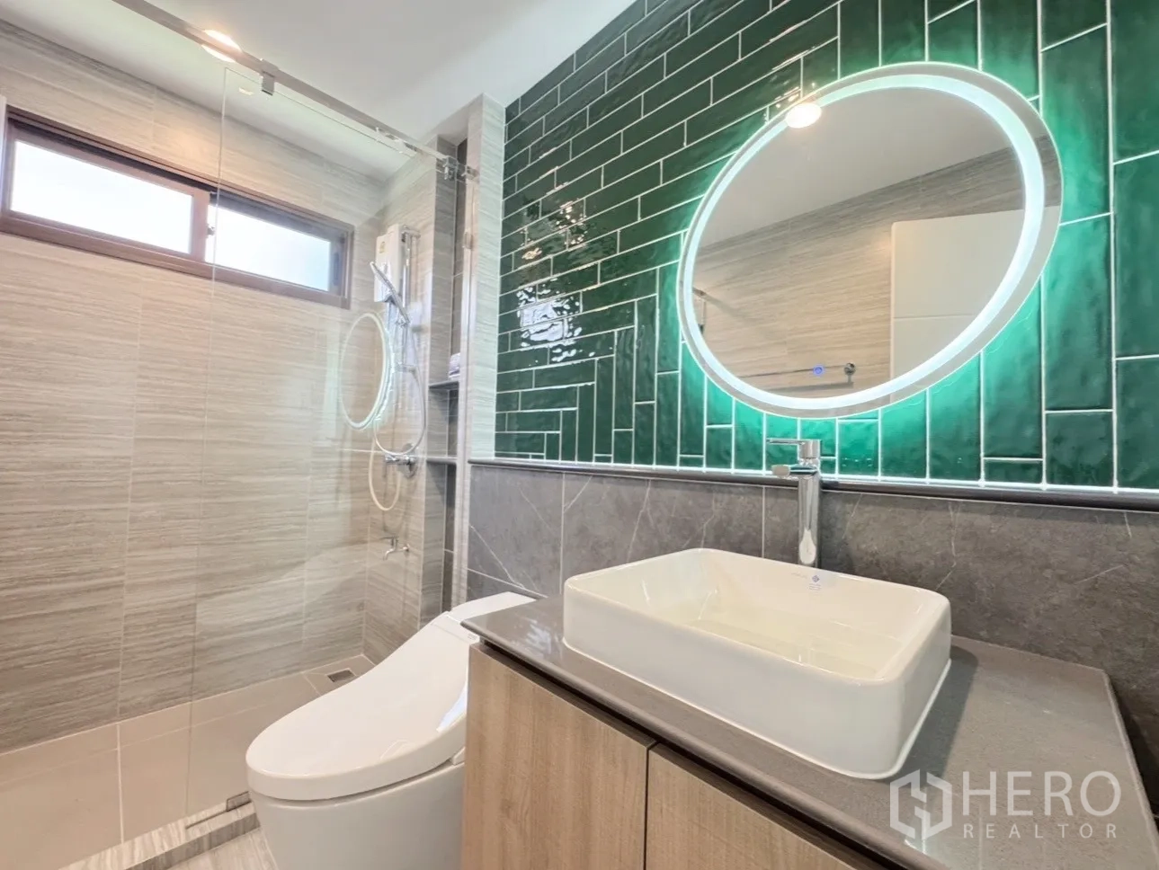 Detached House for rent or sale in Bang Kapi, Bangkok - Modern bathroom with glass shower, green tiled feature wall and LED mirror.