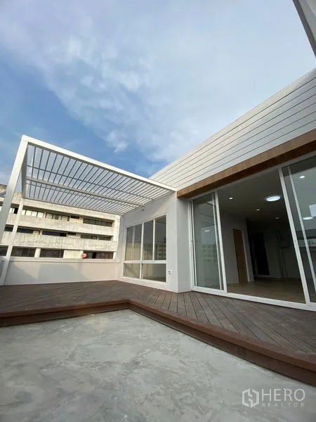 带办公室的家 出租或出售在Suan Luang, Bangkok - 屋顶露台设百叶棚、木质平台与通向室内的推拉玻璃门。