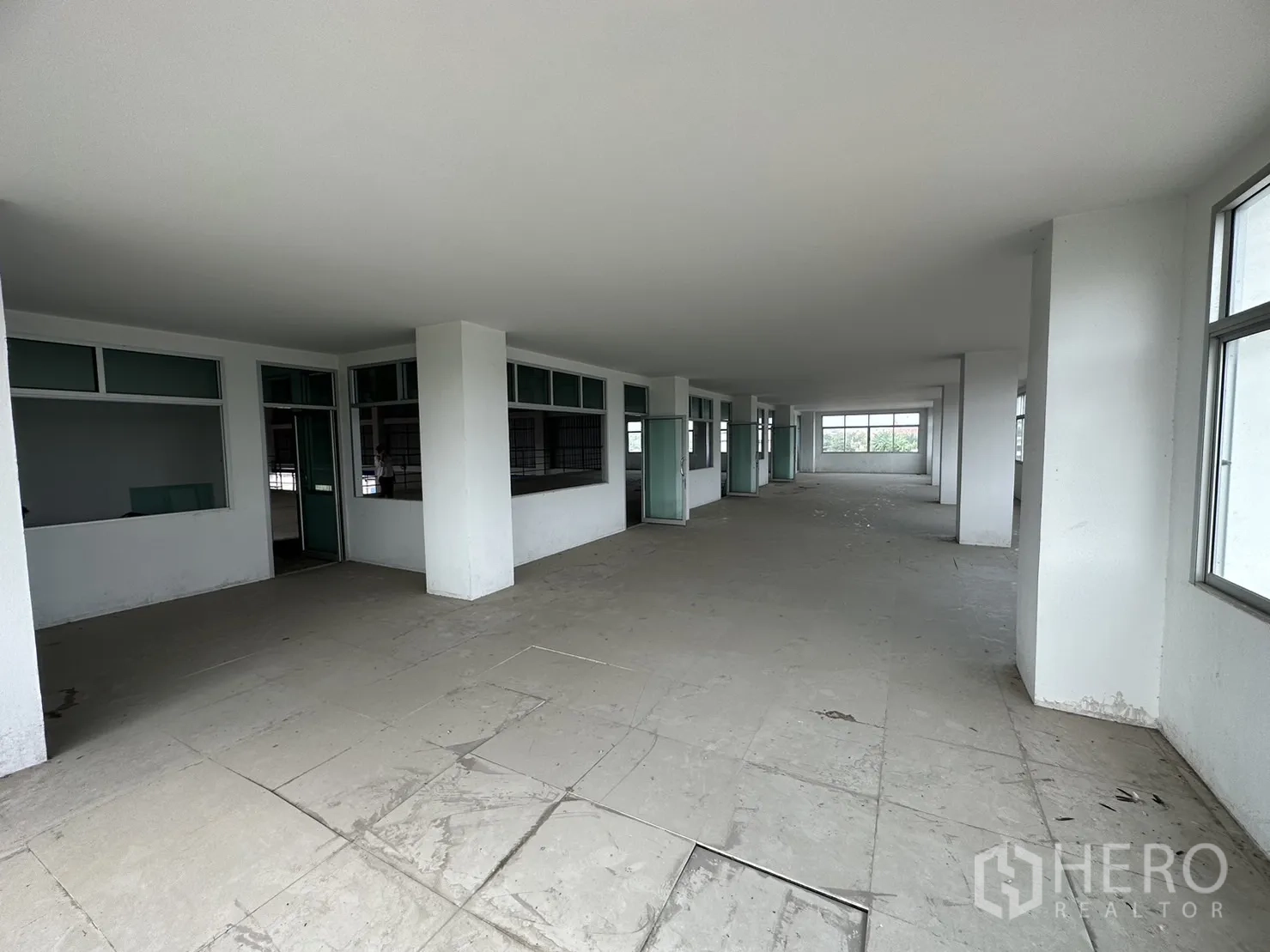 Factory for rent in Pak Kret, Nonthaburi - Open‑plan office level with multiple glass‑partitioned rooms and windows.