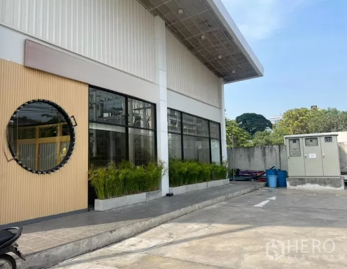 零售空间 出租在Watthana, Bangkok - 建筑侧立面，超大玻璃窗、外挑雨棚与停车区。