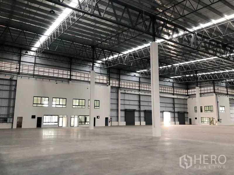 工厂 出租在Samut Prakan - 开阔生产地面，钢梁与天窗，多个装卸门。