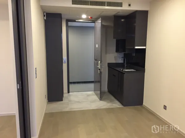 Condominium for sale in Watthana, Bangkok - Compact modern kitchenette and entryway inside a 1-bedroom condominium.